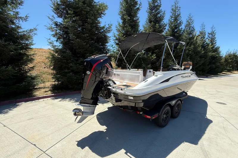 Slide: The Image of 2026 Tahoe 1950 boat on trailer, parked outdoors with trees in background. - 5