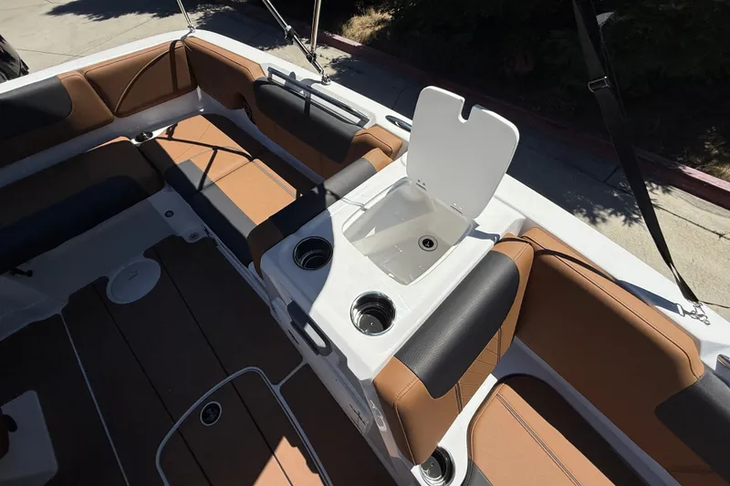 Slide: The Image of 2026 Tahoe 1950 boat interior with tan and black seating, open storage compartment. - 14