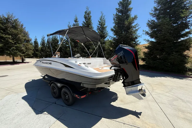 Slide: The Image of 2026 Tahoe 1950 boat with outboard motor on trailer, surrounded by trees. - 4