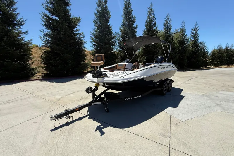 Slide: The Image of 2026 Tahoe 1950 boat on trailer, parked outdoors with trees in the background. - 3
