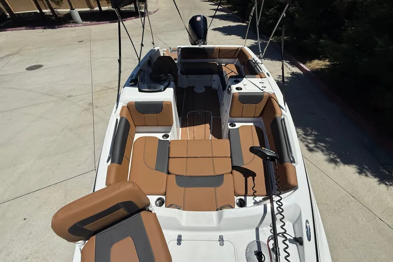 Slide: The Image of 2026 Tahoe 1950 boat interior with brown and gray seating, outdoor setting. - 7