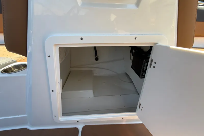 Slide: The Image of Open storage compartment in 2026 Tahoe 1950 boat, featuring white interior and secure latch. - 15