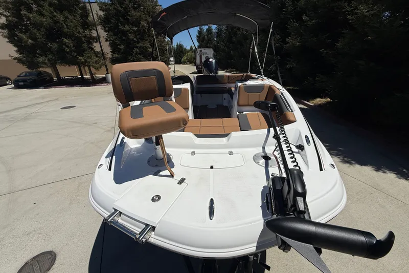 Slide: The Image of 2026 Tahoe 1950 boat with tan seating and trolling motor, parked outdoors. - 11
