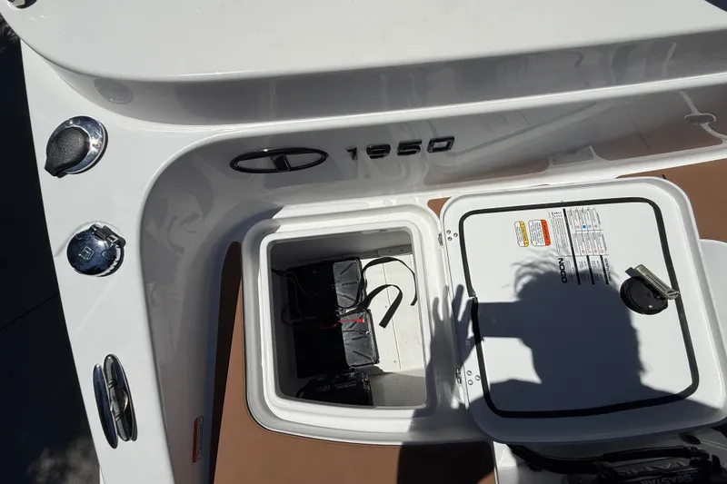Slide: The Image of Open storage compartment on a 2026 Tahoe 1950 boat, showing battery and wiring. - 18