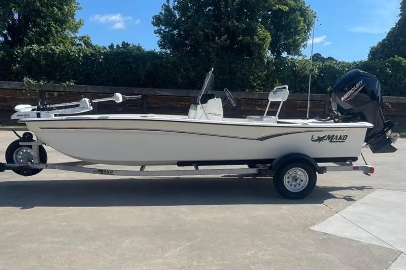 Slide: The Image of 2026 Mako Pro Skiff 17 CC boat on trailer, parked outdoors. - 1