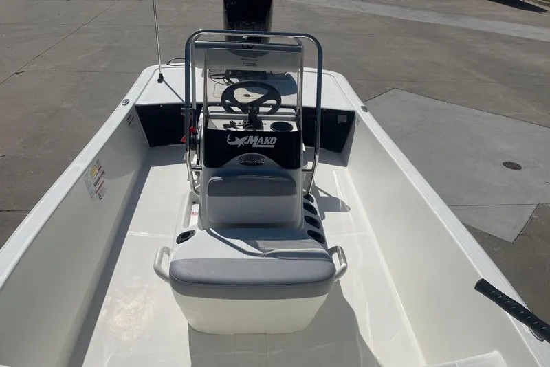 Slide: The Image of 2026 Mako Pro Skiff 17 CC boat interior with steering console and seating. - 2