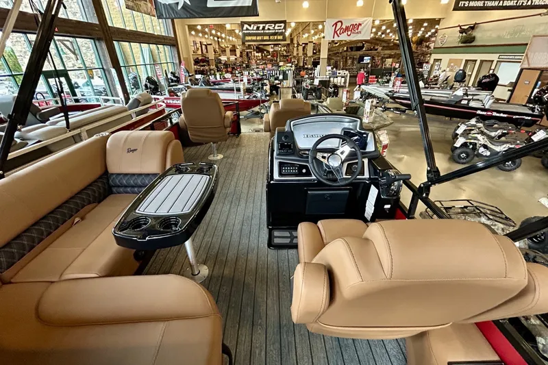 Slide: The Image of 2026 Ranger 220F boat interior with tan seating and modern dashboard in showroom. - 1
