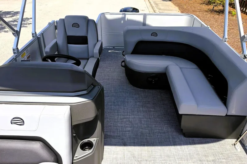 Slide: The Image of 2026 Sun Tracker Party Barge 18 DLX interior with gray seating and steering console. - 11