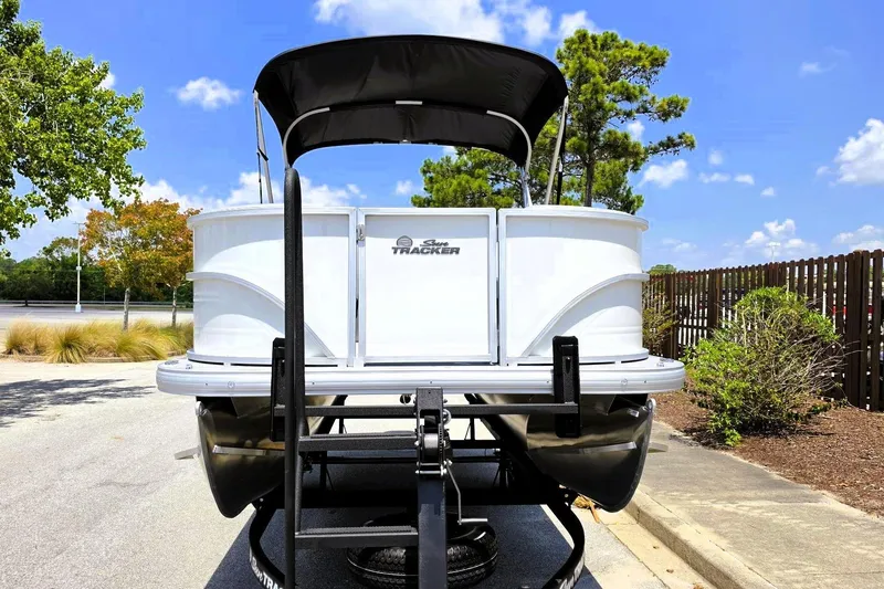 Slide: The Image of 2026 Sun Tracker Party Barge 18 DLX pontoon boat on trailer, parked outdoors. - 5