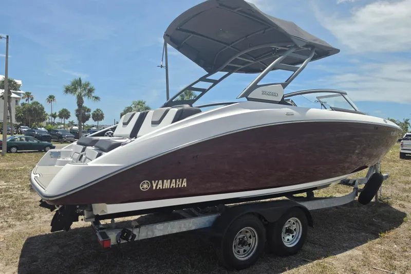 Slide: The Image of 2022 Yamaha Boats 252SD on trailer, parked outdoors under sunny skies. - 2