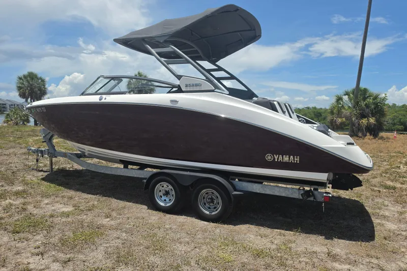 Slide: The Image of 2022 Yamaha Boats 252SD on trailer, parked outdoors under a clear sky. - 7
