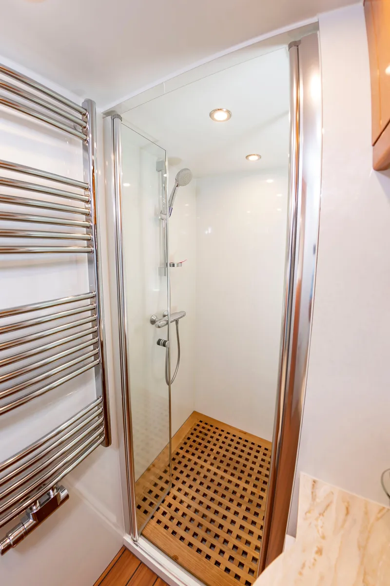 Slide: The Image of A modern shower cabin with wooden flooring and a chrome towel rack. - 45