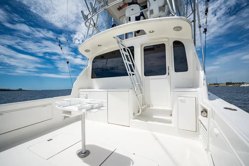Slide: The Image of 2000 Ocean Yachts 43 Super Sport boat deck with fishing setup under clear blue sky. - 12