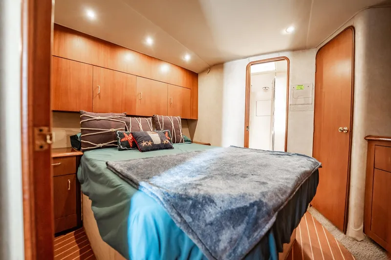Slide: The Image of Luxurious bedroom interior of 2000 Ocean Yachts 43 Super Sport with cozy bedding and wood cabinetry. - 26