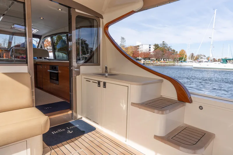 Slide: The Image of 2016 Palm Beach Motor Yachts PB50 interior with elegant wood finishes and marina view. - 4