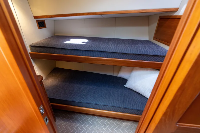 Slide: The Image of 2016 Palm Beach Motor Yachts PB50 cabin with wooden bunk beds and blue cushions. - 62