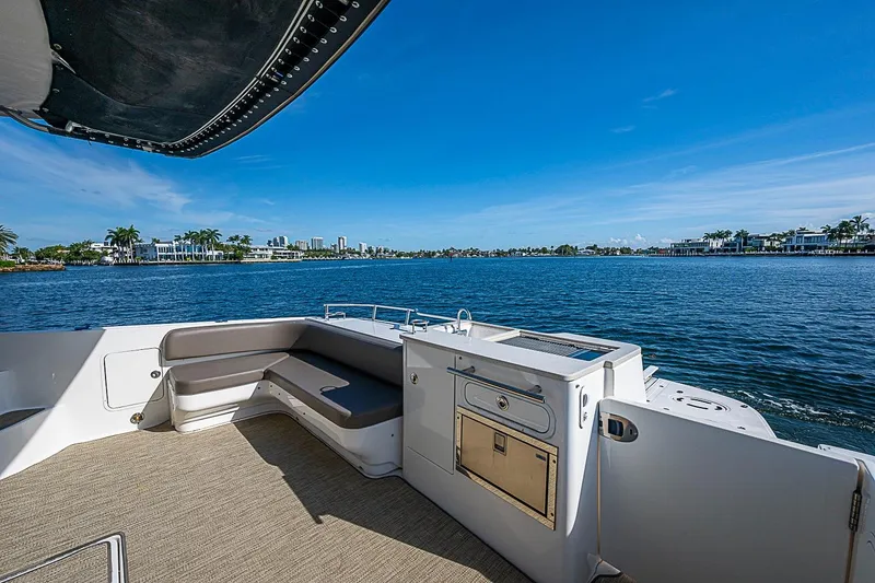 Slide: The Image of 2010 Sea Ray 520 Sedan Bridge yacht deck with seating, overlooking serene waterfront views. - 26