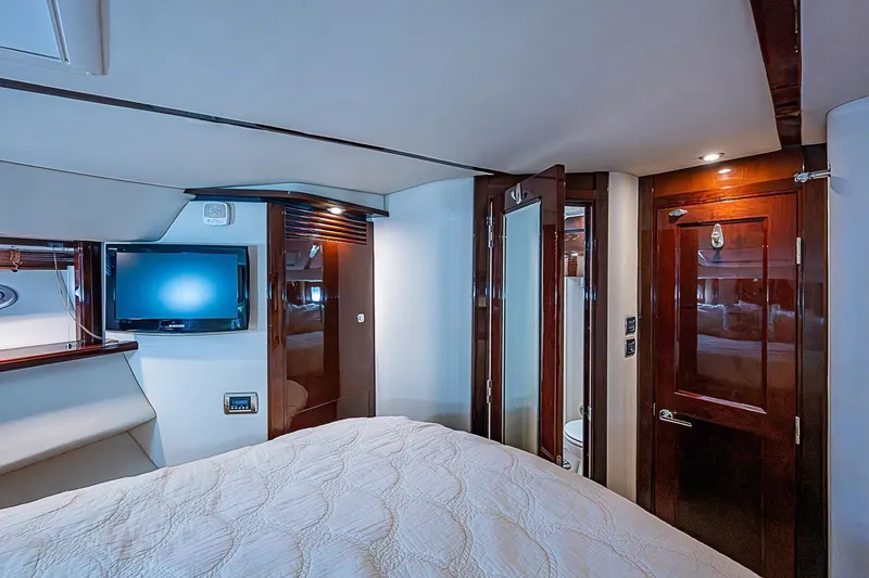 Slide: The Image of Luxurious 2010 Sea Ray 520 Sedan Bridge cabin with TV, wood accents, and cozy bedding. - 49