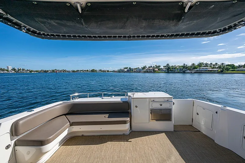 Slide: The Image of 2010 Sea Ray 520 Sedan Bridge yacht deck with seating, overlooking serene waterfront. - 22