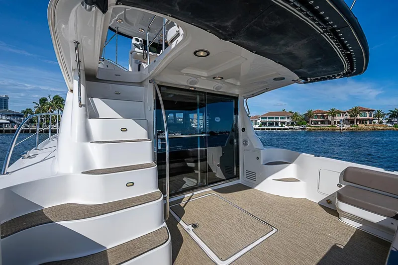 Slide: The Image of 2010 Sea Ray 520 Sedan Bridge yacht deck with stairs and waterfront view. - 15