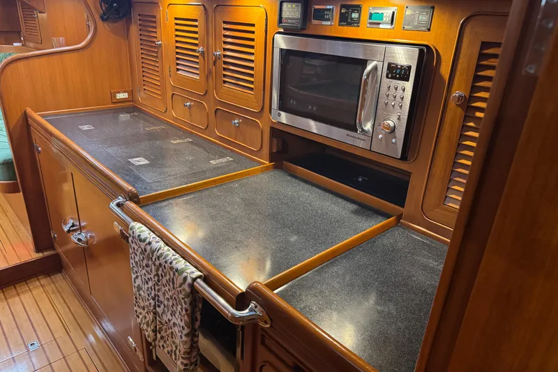 Slide: The Image of Luxurious 2007 Hylas H49 yacht kitchen with wood cabinetry and modern appliances. - 34
