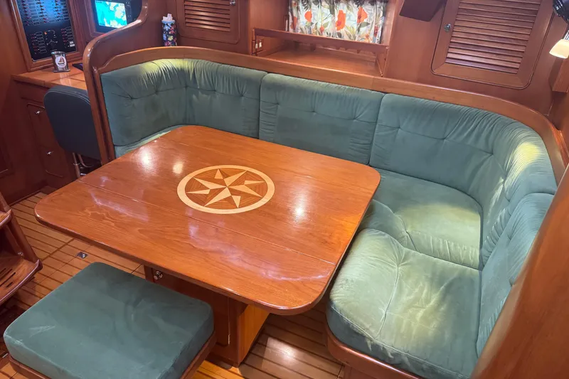 Slide: The Image of Luxurious 2007 Hylas H49 yacht interior with green cushioned seating and wooden table. - 17