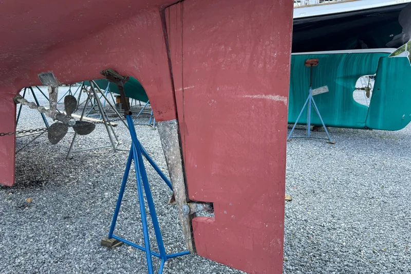 Slide: The Image of 2007 Hylas H49 sailboat hull and propeller on stands in a gravel yard. - 57
