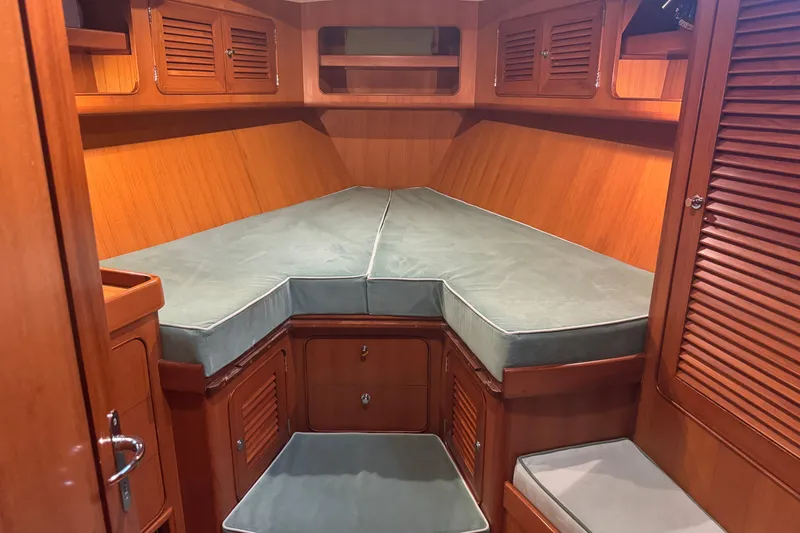Slide: The Image of Luxurious 2007 Hylas H49 yacht cabin with wooden interior and cushioned berth. - 4
