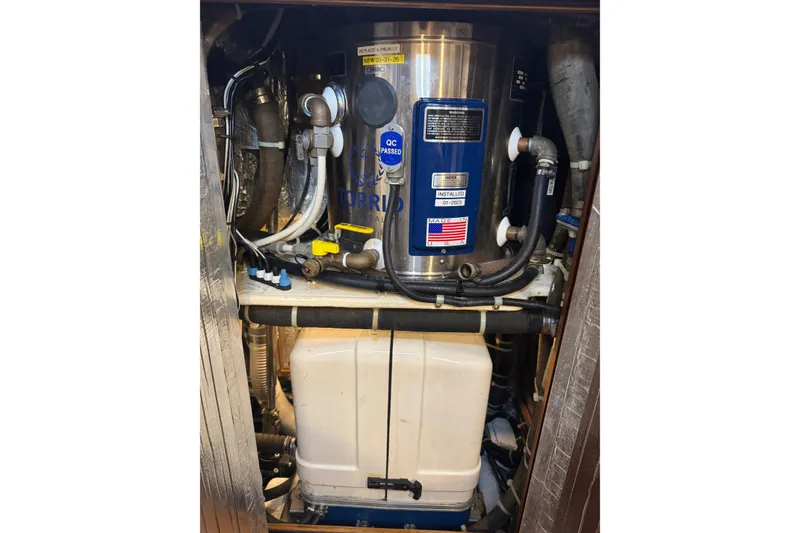 Slide: The Image of Engine room of a 2007 Hylas H49 yacht, featuring mechanical components and piping. - 49