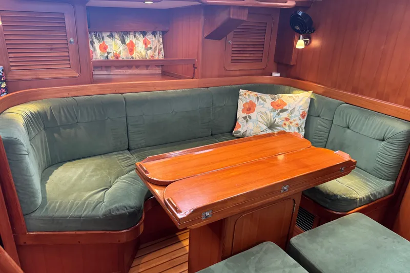Slide: The Image of Cozy interior of 2007 Hylas H49 yacht with green seating and wooden table. - 16