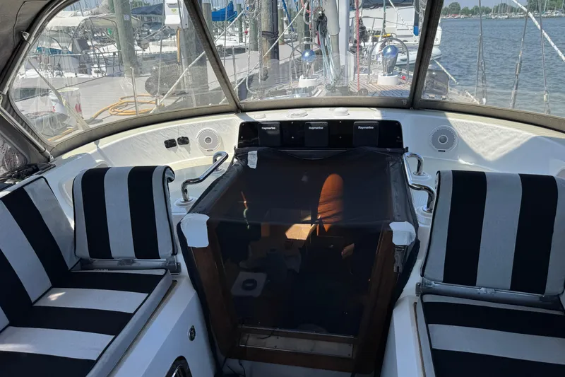 Slide: The Image of Cockpit of 2007 Hylas H49 yacht with striped seating and navigation equipment. - 71