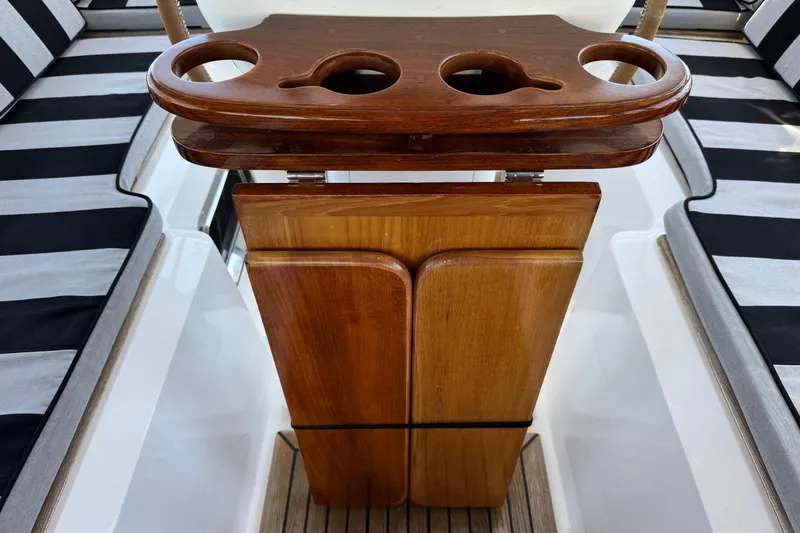 Slide: The Image of Wooden table with cup holders on a 2007 Hylas H49 yacht, featuring striped seating. - 72