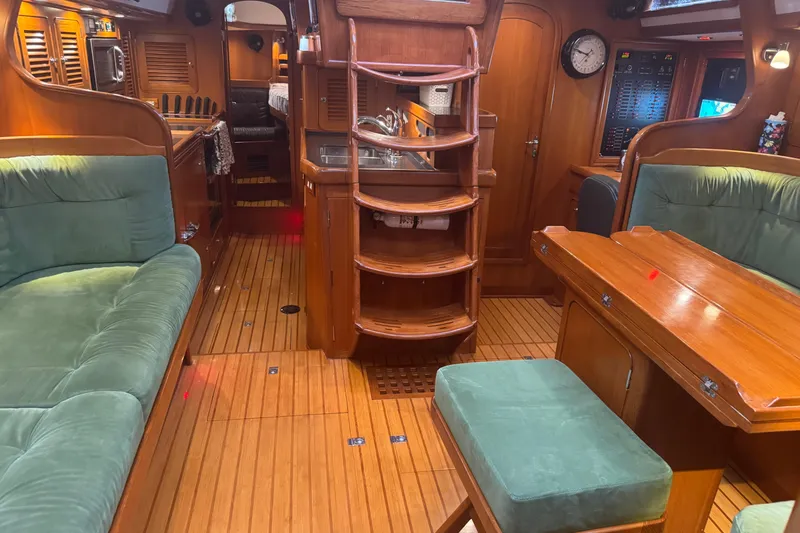 Slide: The Image of Interior of 2007 Hylas H49 yacht with wooden furnishings and green upholstery. - 14