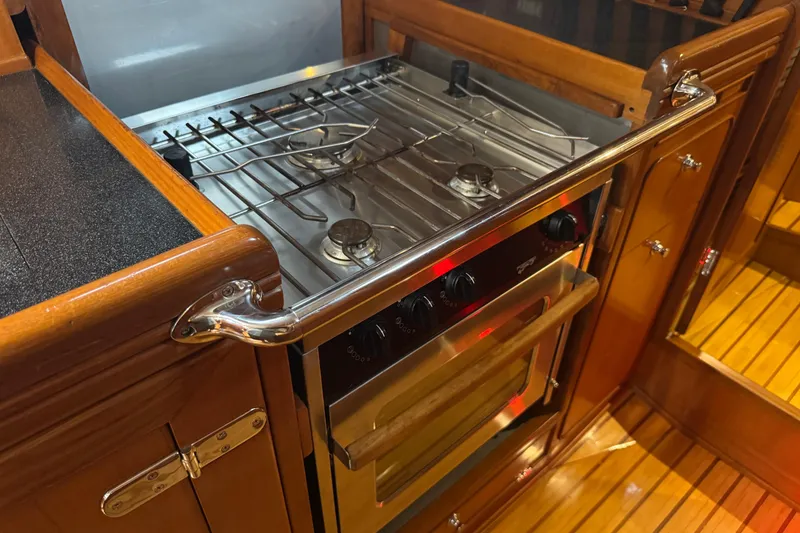 Slide: The Image of Galley kitchen in 2007 Hylas H49 yacht with stainless steel stove and wooden cabinetry. - 30