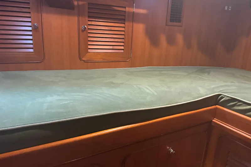 Slide: The Image of Interior cabin of 2007 Hylas H49 yacht with green cushioned berth. - 9