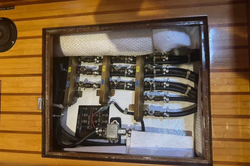 Slide: The Image of Engine compartment of a 2007 Hylas H49 yacht, showcasing hoses and valves. - 52