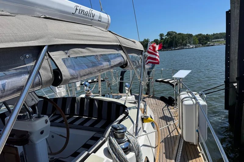 Slide: The Image of Sailboat Hylas H49, 2007 model, docked with American flag, sunny day. - 62