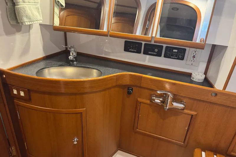 Slide: The Image of Luxurious wooden bathroom vanity on a 2007 Hylas H49 yacht, featuring a sleek sink and mirrored cabinets. - 42