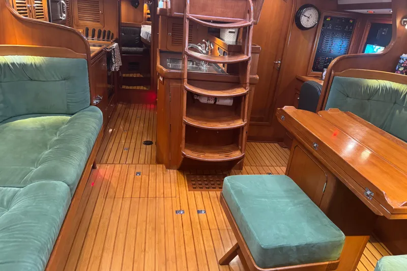 Slide: The Image of Luxurious 2007 Hylas H49 yacht interior with wooden finishes and green upholstery. - 3