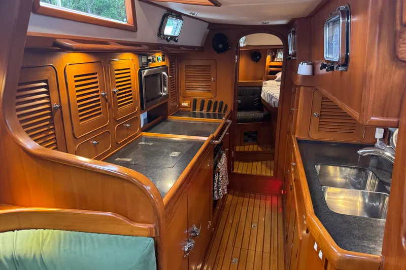 Slide: The Image of Luxurious 2007 Hylas H49 yacht interior with wooden cabinetry and modern kitchen amenities. - 28