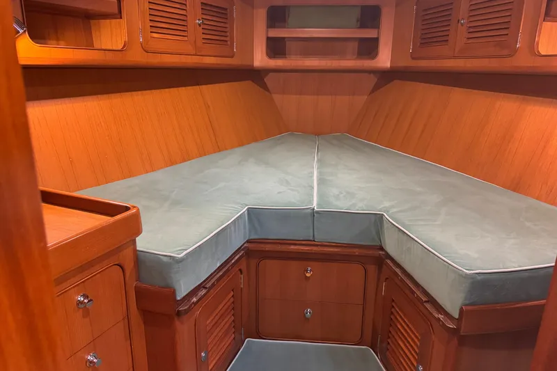 Slide: The Image of Cozy cabin interior of 2007 Hylas H49 yacht with wooden finish and cushioned berth. - 5