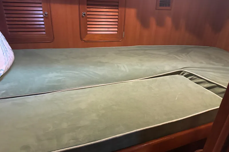 Slide: The Image of Interior cabin of a 2007 Hylas H49 yacht with green cushioned bedding. - 10