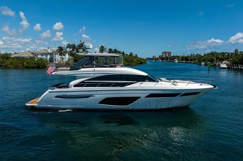Slide: The Image of Luxurious 2020 Princess F70 yacht cruising on a scenic waterway under a clear blue sky. - 0