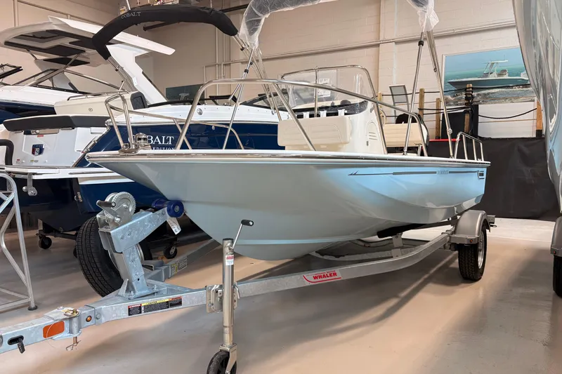 Slide: The Image of 2026 Boston Whaler 150 Montauk boat on trailer in showroom. - 0