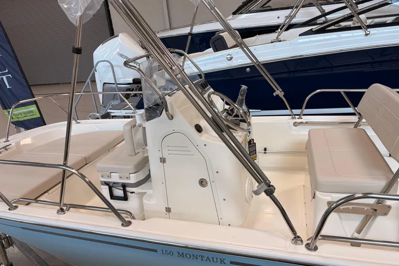 Slide: The Image of 2026 Boston Whaler 150 Montauk boat interior with seating and steering console. - 5