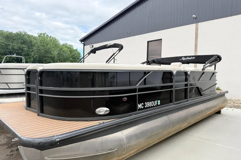 Slide: The Image of 2019 Misty Harbor 2285CF pontoon boat with black exterior, docked near a building. - 2