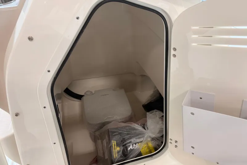 Slide: The Image of Storage compartment inside 2026 Boston Whaler 210 Montauk boat, featuring organized space and accessories. - 16