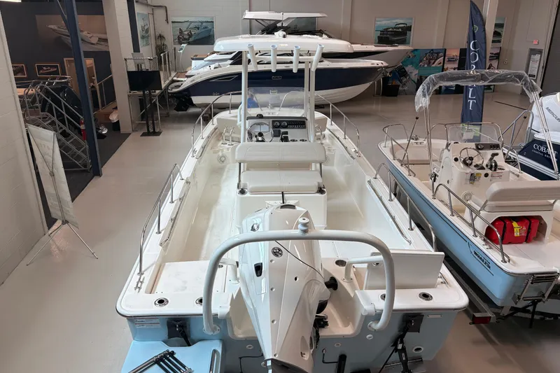 Slide: The Image of 2026 Boston Whaler 210 Montauk boat displayed in a showroom, showcasing sleek design and spacious interior. - 5