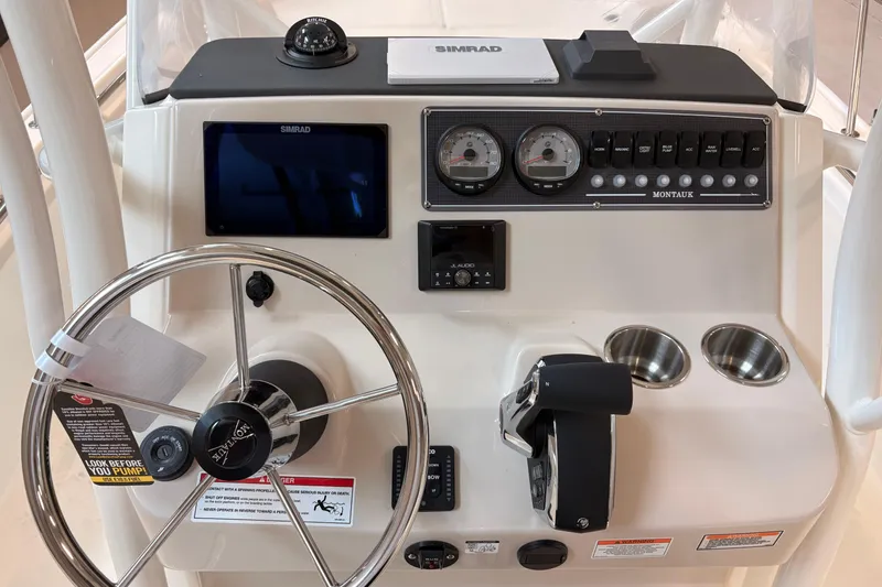 Slide: The Image of 2026 Boston Whaler 210 Montauk dashboard with steering wheel, gauges, and controls. - 8