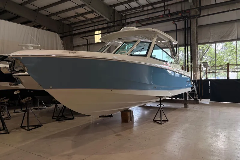 The Image of 2026 Boston Whaler 330 Vantage boat in a warehouse, showcasing sleek design and modern features. - 0